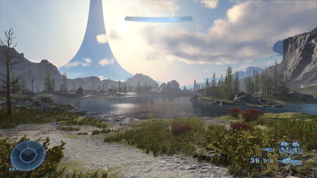 An image depicting a small lake, a grass landscape, lightly clouded blue sky and a Halo ring in the background.