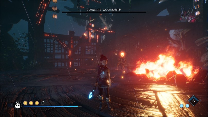 Kena in a dark and crumbling forge of the Woodsmith. There is fire in the background and Kena looks fierce and not amused after defeating the boss.