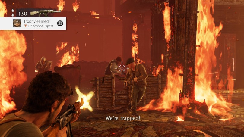 Nate shooting a a couple of enemies in a heavily burning building.