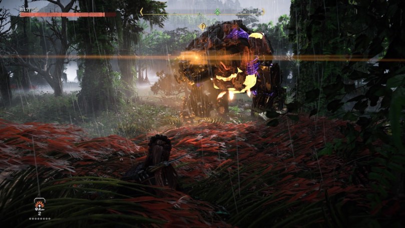 A screenshot of Horizon Forbidden West showing Aloy in tall grass hiding from a Fireclaw.