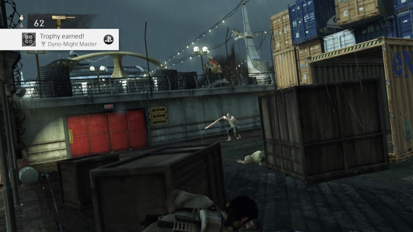 A screenshot of Uncharted showing Nate on a ship hiding behind wooden boxes.