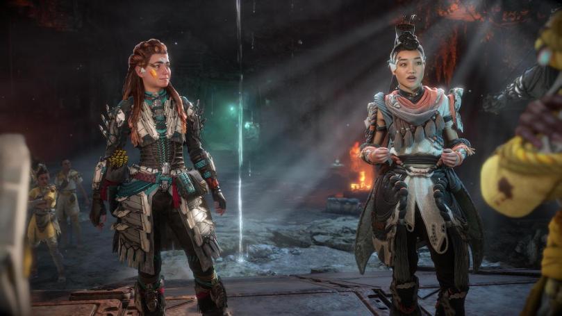 Aloy and Seyka awkwardly trying to convince other Quen fanatics that they also want to join their cult. Seyka does the talking while Aloy looks at her, smiling awkwardly.