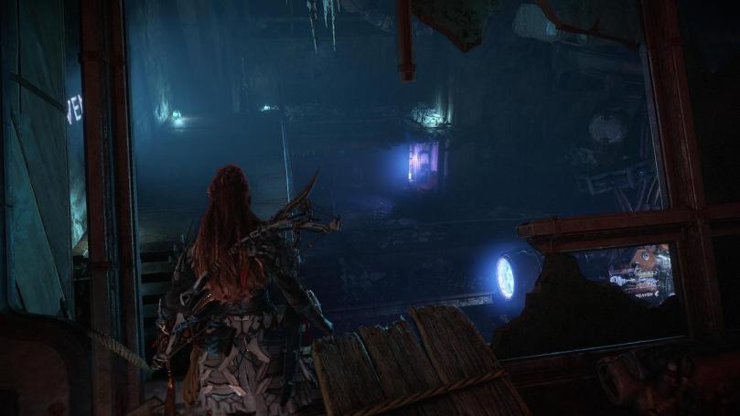 Aloy examining one of the dark and creepy Old World ruins.