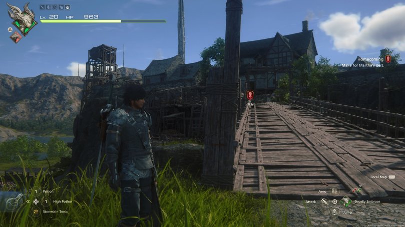 Clive stands in front of the wooden bridge to Martha's Rest, a small village in the background that rests on a plateau.