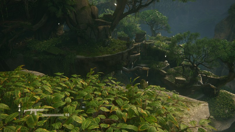 Nathan hides in tall grass to evade the gazes of several searching enemies. The terrain is complex, rocky, and full of grass and trees.
