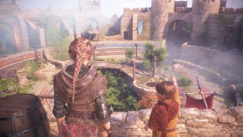 Amicia and Hugo on the battlements og Chateau d'Ombrage looking at the courtyard on a sunny day